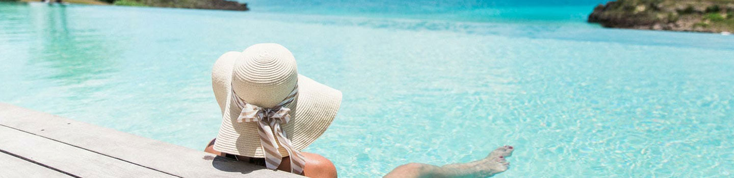 woman in a sun hat relaxing in the pool