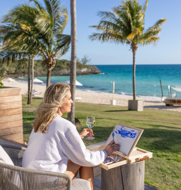 Woman painting the beach with champagne at our Bahamas resort